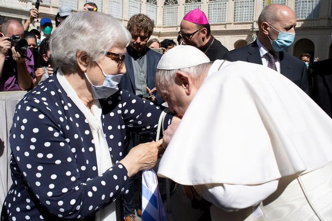 Pope Francis greets a Holocaust survivor Lidia Maksymowicz and kisses a concentration camp number tattooed on her arm after the weekly general audience at the San Damaso courtyard, at the Vatican, May 26, 2021. Vatican Media/ Handout via REUTERS/File Photo