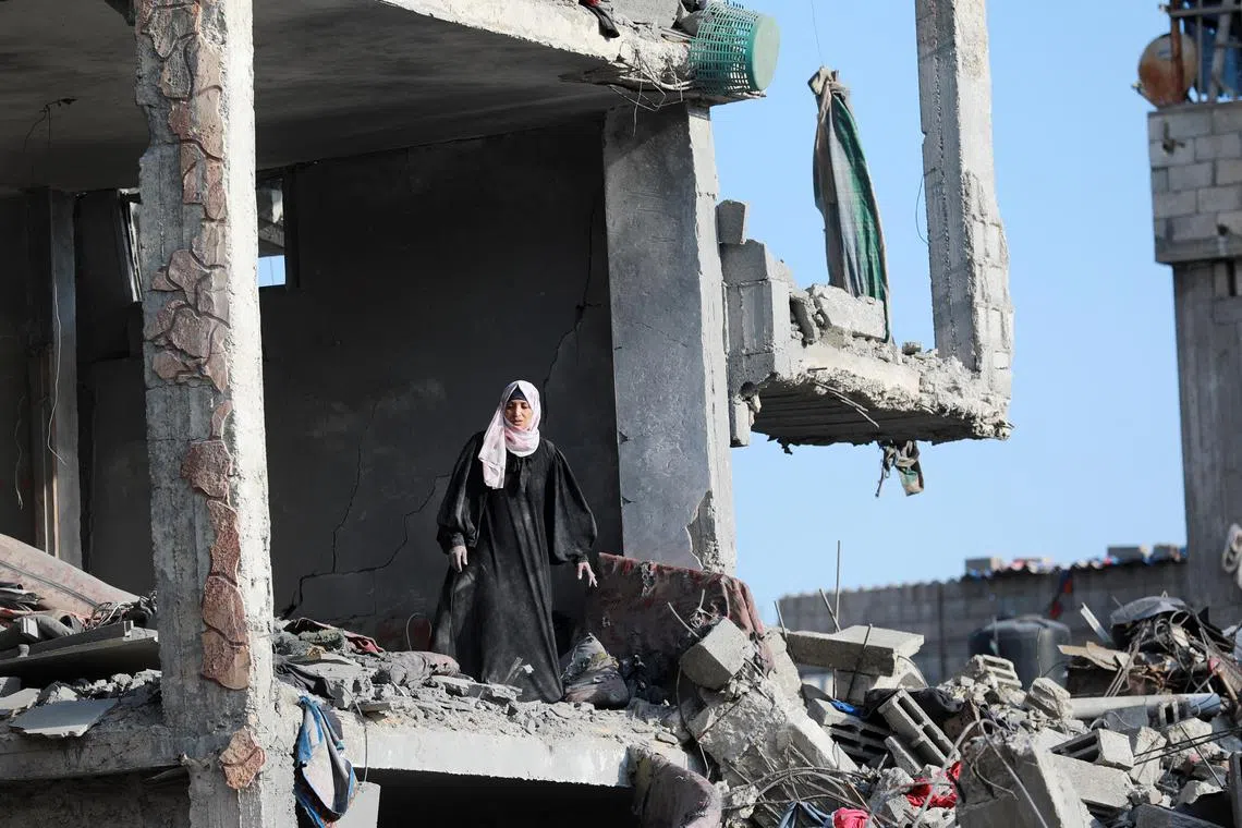 A Palestinian woman standing inside a destroyed building after Israeli forces withdrew from a part of Nuseirat, following a ground operation amid the ongoing conflict between Israel and Hamas, in Nuseirat, central Gaza Strip, on Nov 29. 