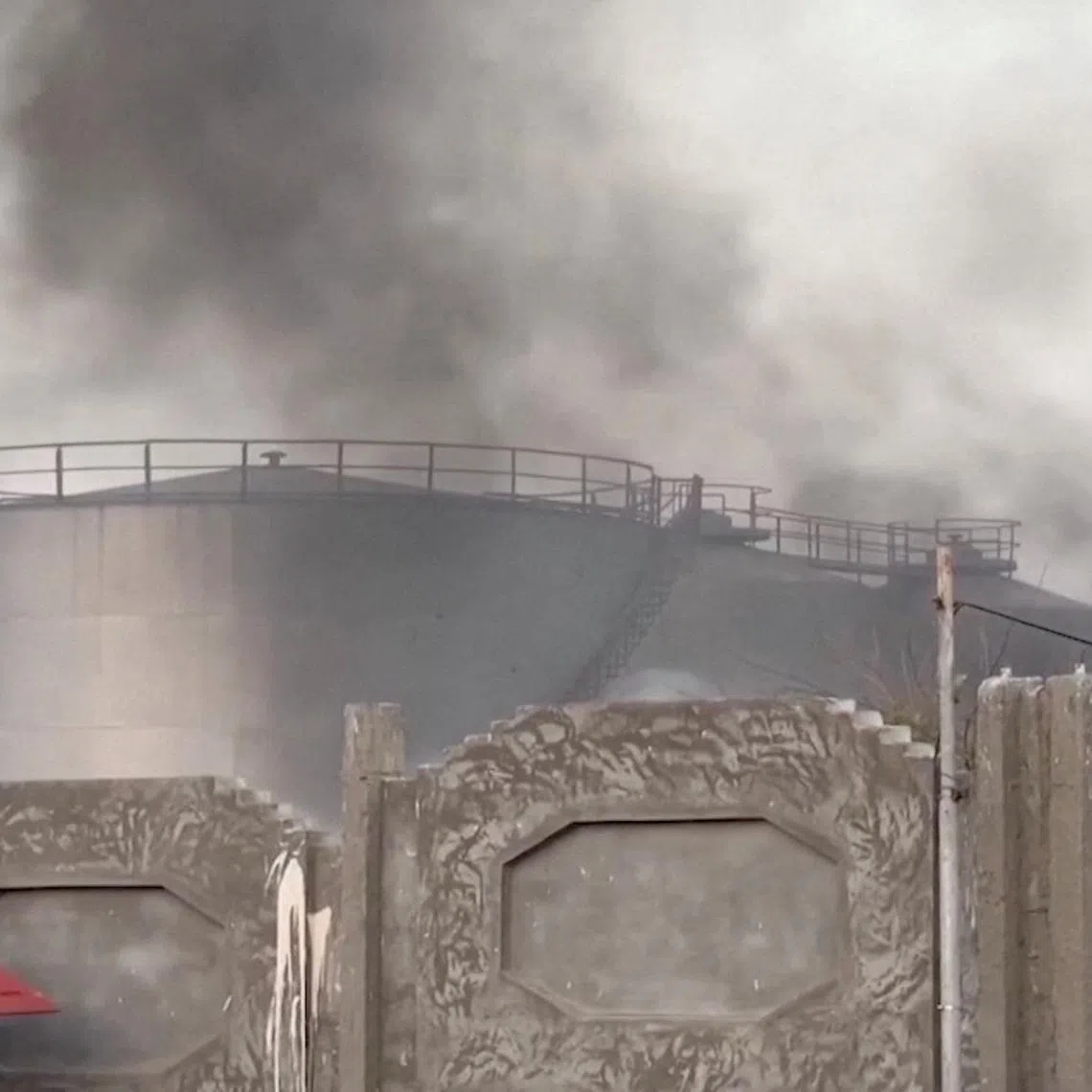 A person gestures towards smoke rising in the aftermath of a Saudi-led coalition airstrike, which targeted what it described as foreign military support to UAE-backed southern separatists, in Yemen's southern port of Mukalla, in this screengrab from a handout video obtained by Reuters on December 30, 2025. Aden al-Mustakillah TV/Handout via REUTERS