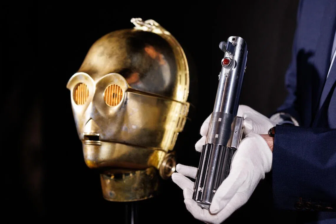 A Light-Up C-3PO Head and Hero Lightsaber Hilt featured in the Star Wars films are displayed by Propstore auction house in Rickmansworth, Hertfordshire, Britain, on Jan 30.