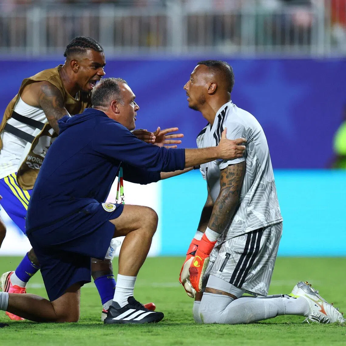 An exhausted, dazed Eloy Room being celebrated by members of the Curacao squad, after his extraordinary goalkeeping performance in their 0-0 World Cup draw with Ecuador on June 20.