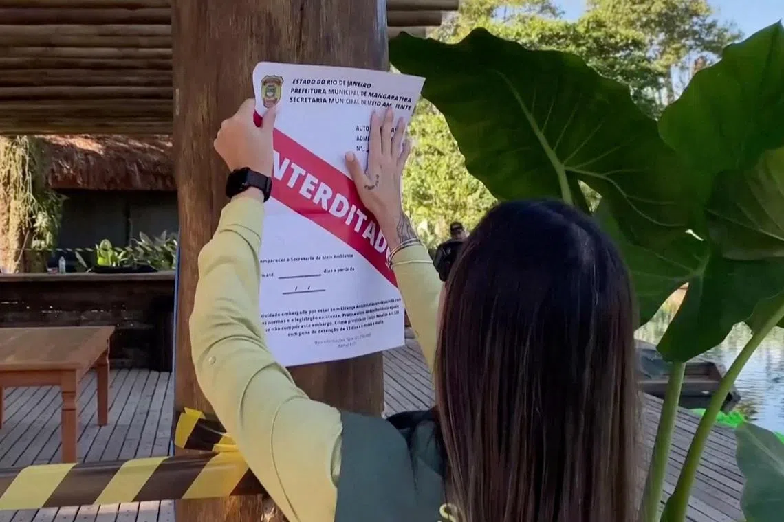 An official sticks an "Interdict" sign as construction is halted on a property of Brazilian football star Neymar in Mangaratiba, Brazil, over environmental violations on Thursday.