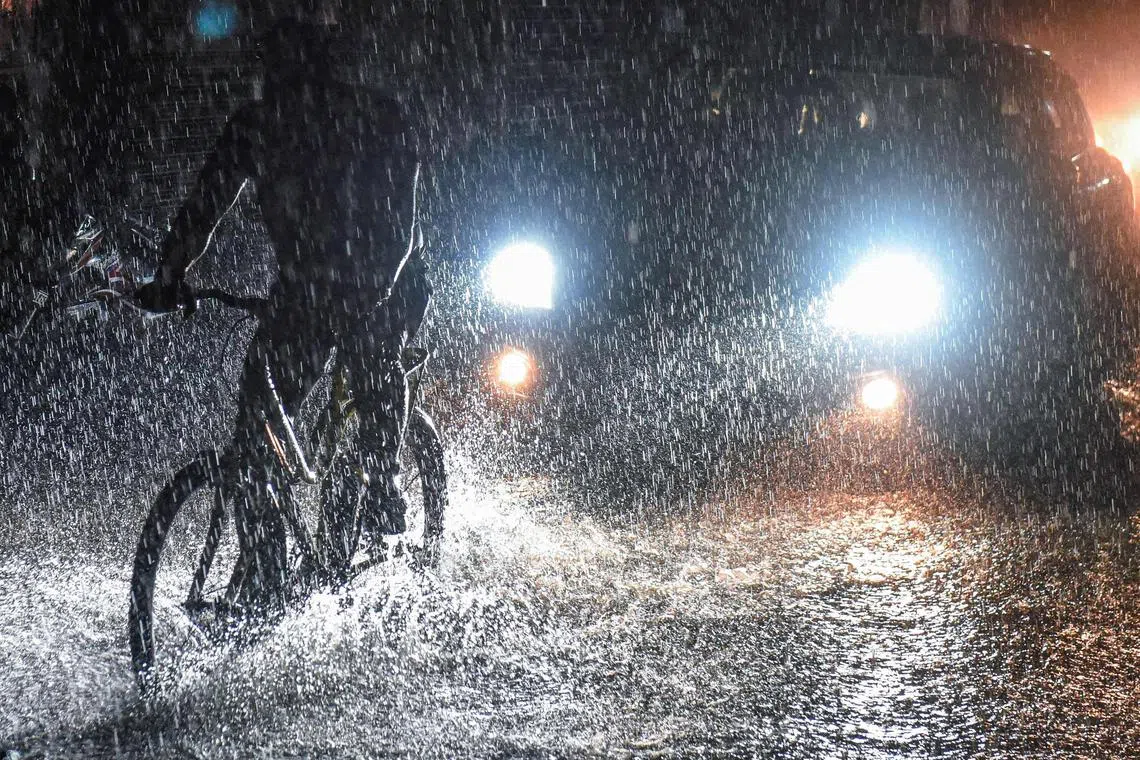 Commuters make their way through a waterlogged street during a heavy rainfall in Amritsar, India on June 25, 2023. 