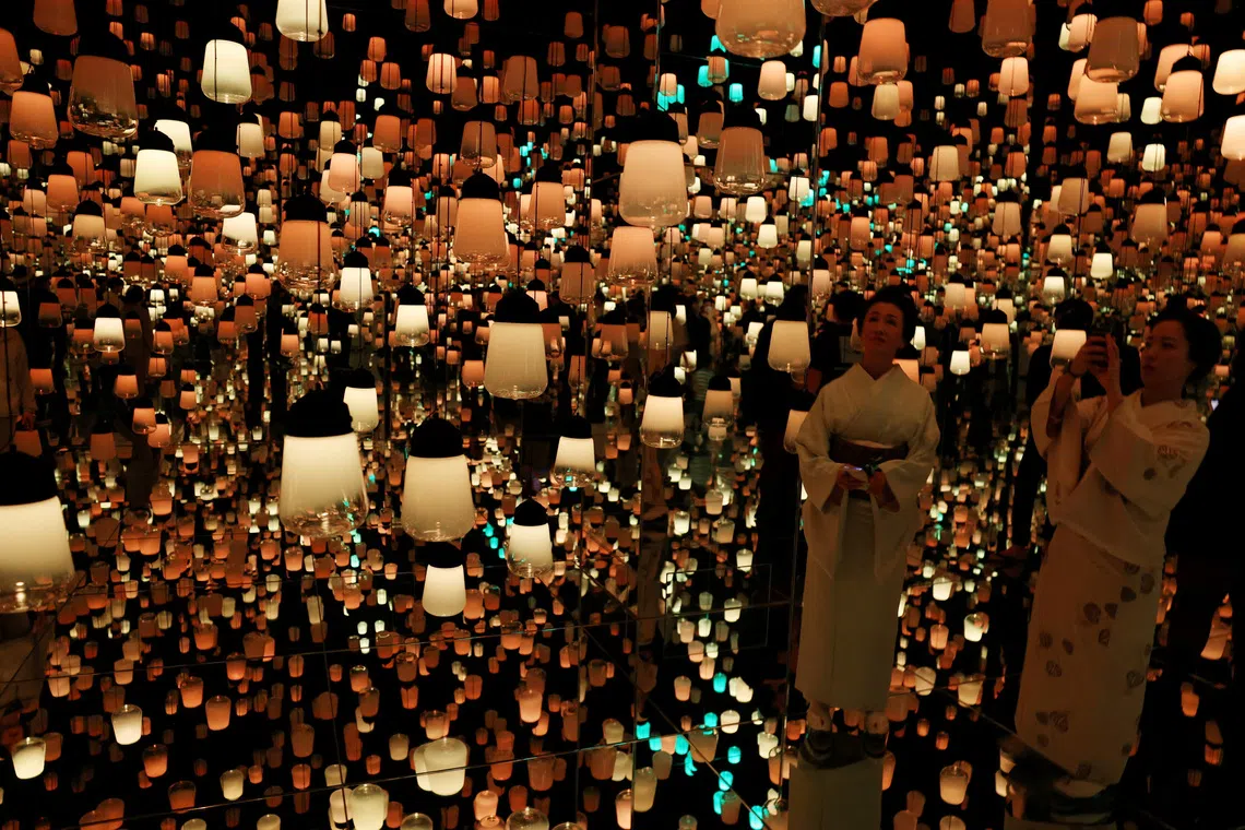 A photo relased on Nov 11, 2025 showing visitors dressed in traditional Japanese kimonos watching digital artwork at teamLab Biovortex in Kyoto, Japan.