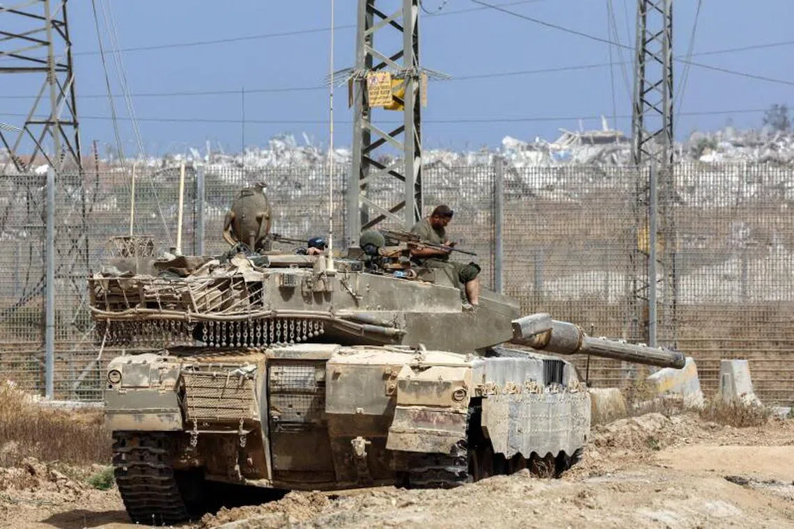 Caption:
Israeli soldiers sit on the turret of a tank in southern Israel, on the border with the Gaza Strip, on May 27, 2025. Israeli Prime Minister Benjamin Netanyahu vowed May 26 to bring back all hostages, "living and dead", as Gaza rescuers said Israeli strikes killed at least 52 people in the war-battered Palestinian enclave. (Photo by Jack GUEZ / AFP)