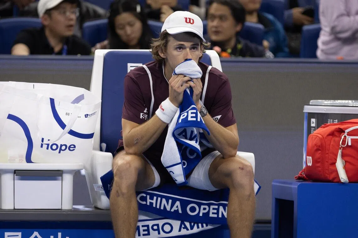 Alex De Minaur reacts after retiring from the men’s final singles match against Novak Djokovic at the China Open in Beijing on Oct 6.
