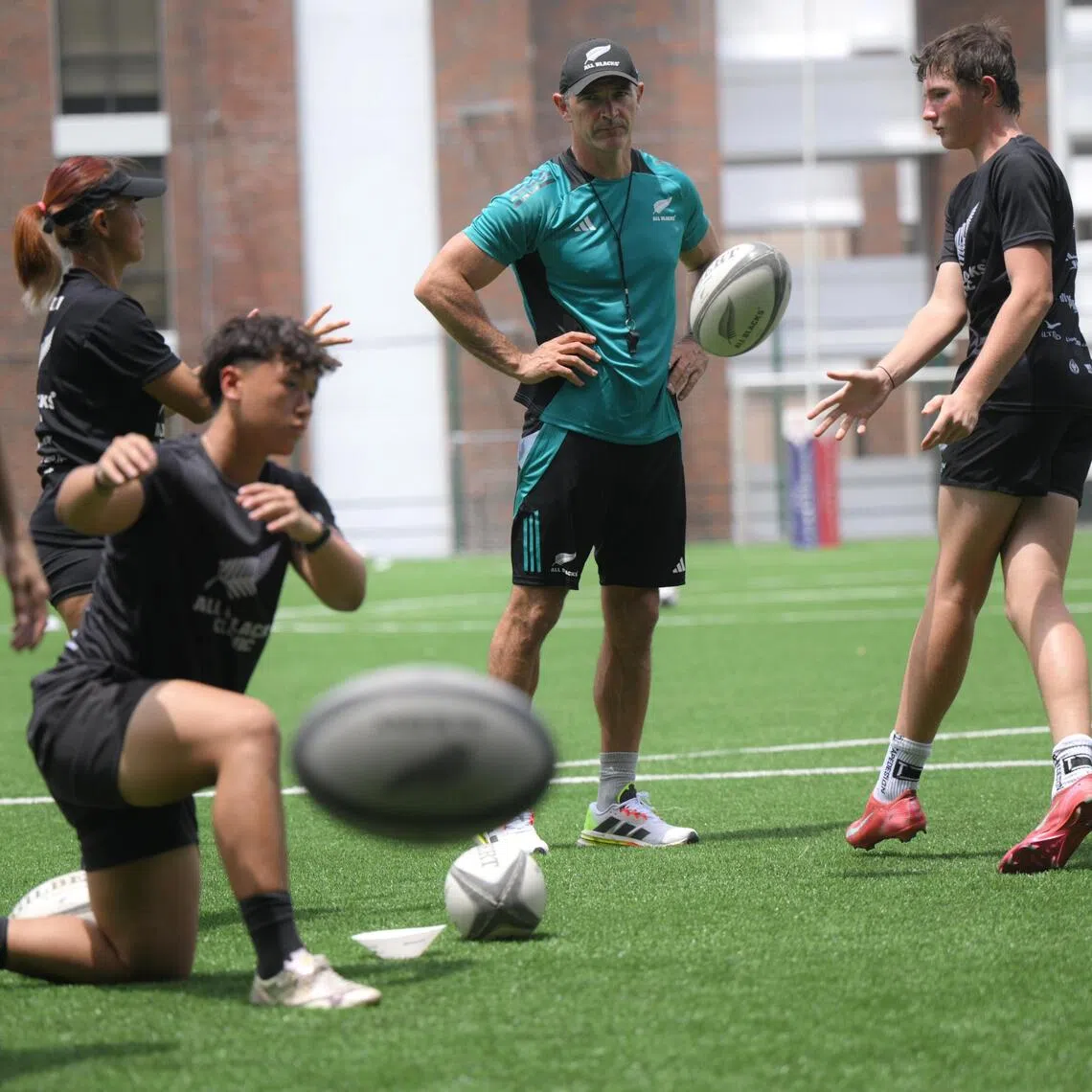 Retired New Zealand rugby union player Stephen Donald (centre), 41, supervises a rugby clinic at Tanglin Trust School on October 23, 2025.