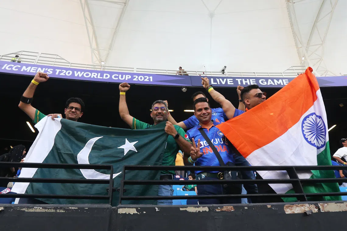 Cricket - ICC Men's T20 World Cup 2021 - Super 12 - Group 2 - India v Pakistan - Dubai International Stadium, Dubai, United Arab Emirates - October 24, 2021 India and Pakistan fans display their flags in the stand before the match REUTERS/Satish Kumar