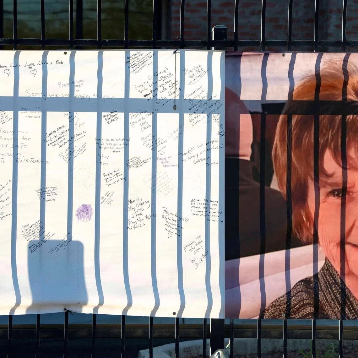 A banner with a growing collection of well-wishes from supporters reads \"bring her home\" (not pictured) and shows a photo of Nancy Guthrie, the 84-year-old mother of U.S. journalist and television host Savannah Guthrie, who disappeared from her home nearly two weeks ago, outside of the KVOA newsroom in Tucson, Arizona, U.S., February 14, 2026. REUTERS/Rebecca Noble