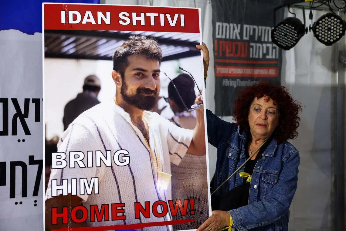 FILE PHOTO: A woman holds a poster with an image of Idan Shtivi, in Tel Aviv, Israel, as hostages are released by the Palestinian militant group Hamas, amid a hostages-prisoners swap deal between Hamas and Israel, November 26, 2023. REUTERS/Athit Perawongmetha/File photo