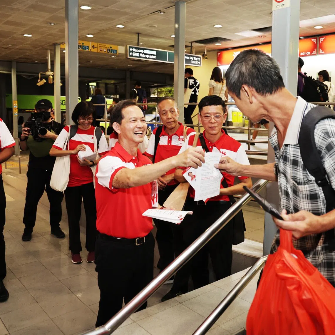 PSP chief Leong Mun Wai (centre) passing a supporter a PSP leaflet during walkabout with Sani Ismail (far left) at Lakeside MRT area on April 25.