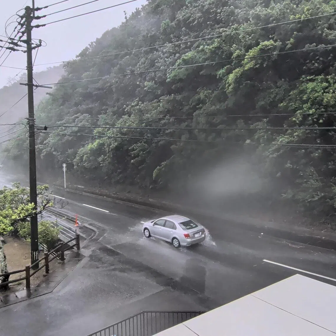 A car makes its way through strong winds and rain as Typhoon Dolphin approaches Kagoshima in Japan on Aug 7.