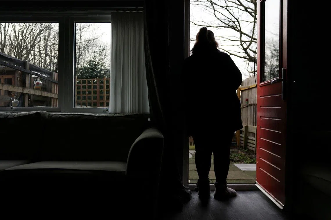 FILE PHOTO: A woman poses at her home in England, Britain, January 8, 2025. She was 14 when she was sexually abused by a grooming gang in Rochdale. REUTERS/Hollie Adams/File Photo