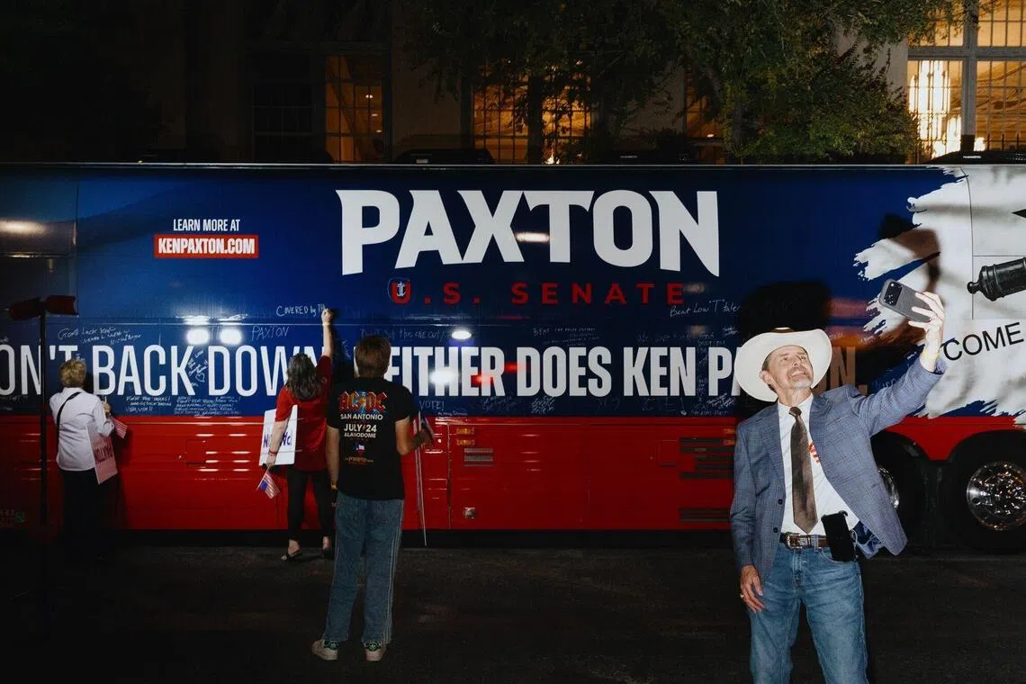 Attendees sign and take selfies with the Paxton campaign tour bus following a “Come and Take It Tour” campaign event with Ken Paxton, Texas attorney-general and Republican US Senate candidate.