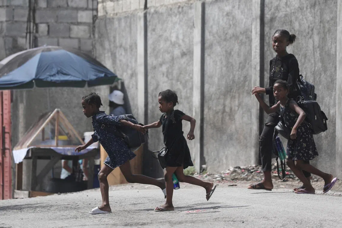FILE PHOTO: A woman and three children flee their home from gang violence, in Port-au-Prince, Haiti October 20, 2024. REUTERS/Ralph Tedy Erol/File Photo