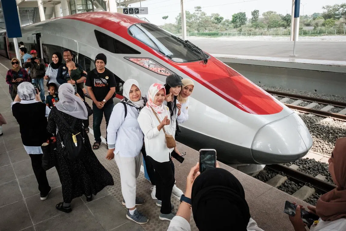 People take photos with the first car of the Jakarta-Bandung high-speed train at the Tegalluar station in Bandung, West Java, on Sept 17, 2023.
