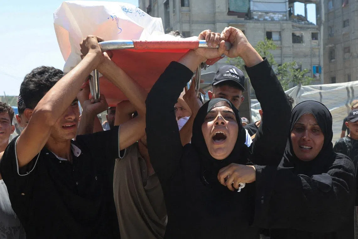 Mother of Palestinian child Muataz Abu Shaar, who was killed by Israeli fire, according to medics, and other mourners carry his body during his funeral  in Khan Younis, in the southern Gaza Strip, July 14, 2026. REUTERS/Ramadan Abed