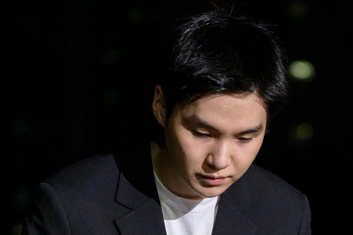 South Korean singer Suga of K-pop mega group BTS bows in front of the media as he arrives at a police station in the Yongsan district of Seoul on August 23, 2024 for questioning after being charged with riding an electric scooter while under the influence late night on August 6. (Photo by ANTHONY WALLACE / AFP)