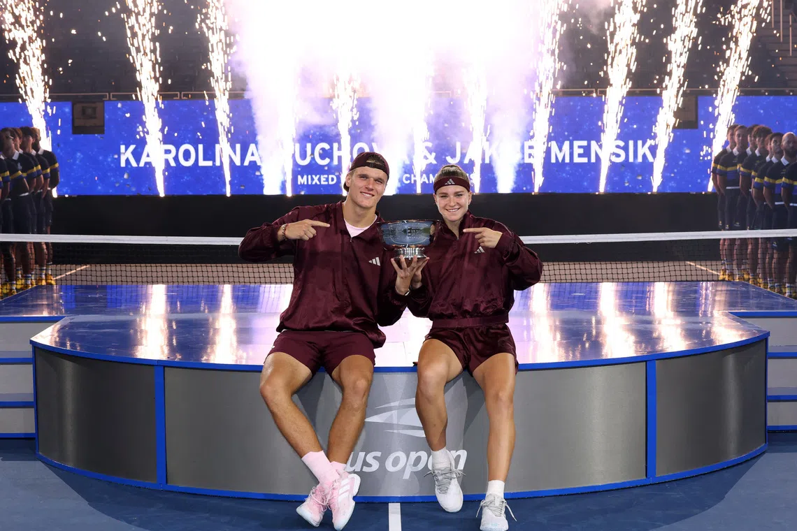 Czech Republic’s Jakub Mensik and Karolina Muchova pose with the trophy after winning their US Open mixed-doubles final match.