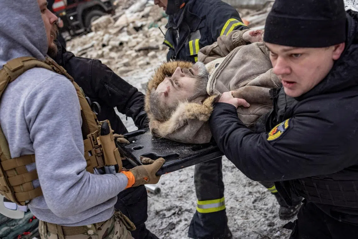 Police evacuate a local resident from a residential building heavily damaged during a Russian missile attack, in Kharkiv.