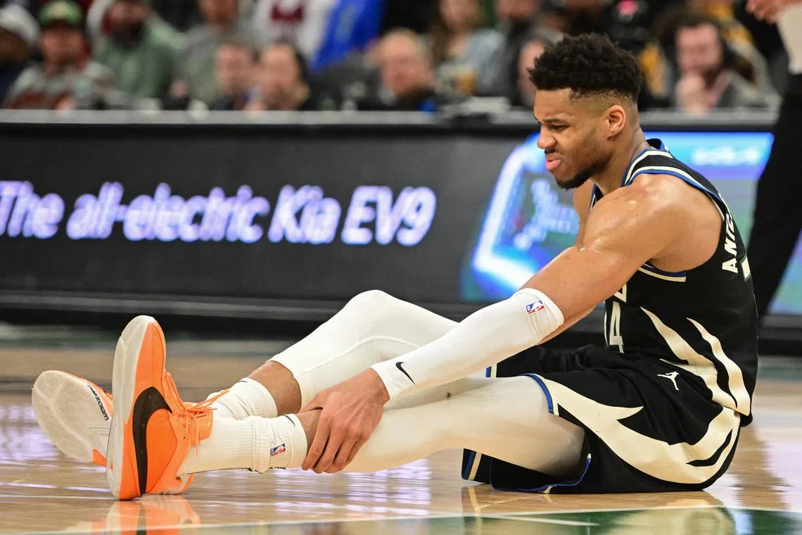 Milwaukee Bucks forward Giannis Antetokounmpo grabs his leg in the third quarter and left the game against the Boston Celtics with an injury at Fiserv Forum.