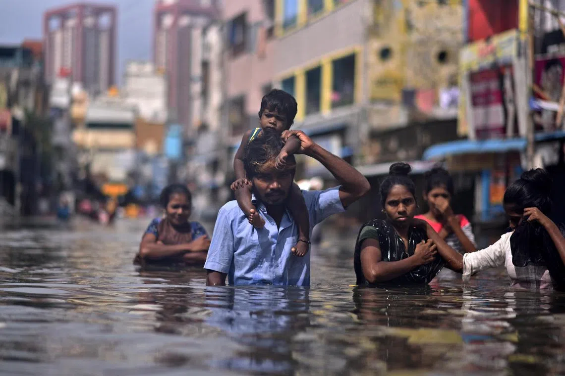 epa11011612 People wade through a flooded street following heavy downpour during 'Cyclone Michaung', in Chennai, India, 05 December 2023. As the cyclone approaches the coast of North Tamil Nadu, several areas are already inundated and affected by severe floods with the region experiencing even more rainfalls. The Indian Meteorological Department has issued a red alert for heavy rains in Chennai as the cyclonic storm, 'Cyclone Michaung' is anticipated to make landfall near Bapatla on the Andhra Pradesh coast later on 05 December.  EPA-EFE/IDREES MOHAMMED