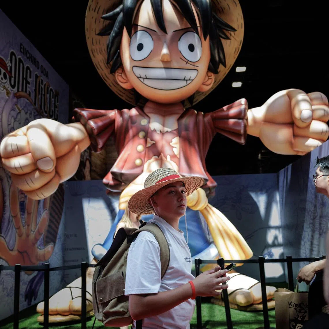 A person walks by a statue of Luffy, a character from the Japanese manga and anime One Piece at Japan Expo Paris in Villepinte, north of Paris, on July 9.