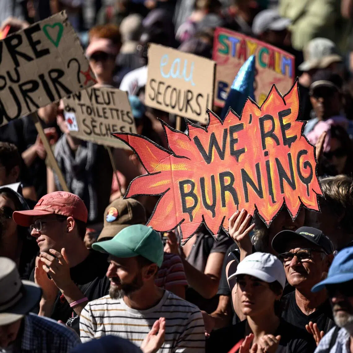 Demonstrators hold placards during a climate protest in Lausanne, Switzerland, on Sept 19.