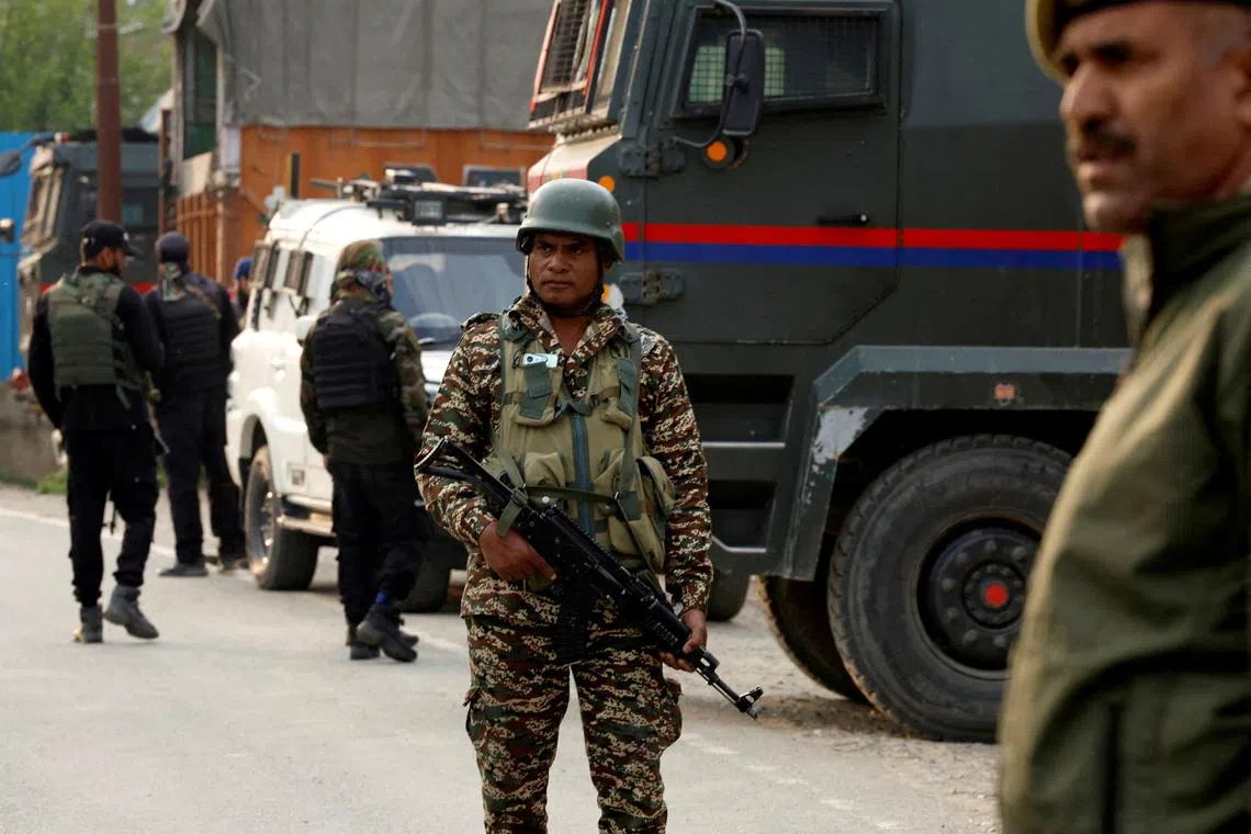 Indian security force personnel stand guard near the site of a fighter jet crash in Wuyan in India-administered Kashmir's Pulwama district, May 7, 2025. REUTERS/Sharafat Ali