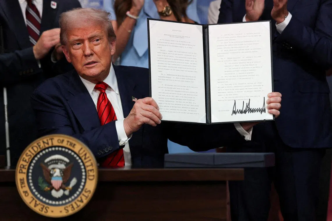 FILE PHOTO: U.S. President Donald Trump holds up an executive order in the South Court Auditorium on the White House campus in Washington, D.C., U.S., August 5, 2025. REUTERS/Jonathan Ernst/File Photo