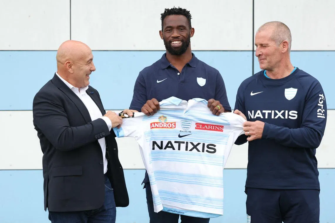 Siya Kolisi poses with his Racing 92 jersey next to president Laurent Travers (left) and head coach Stuart Lancaster after his official presentation at the headquarters of the club.