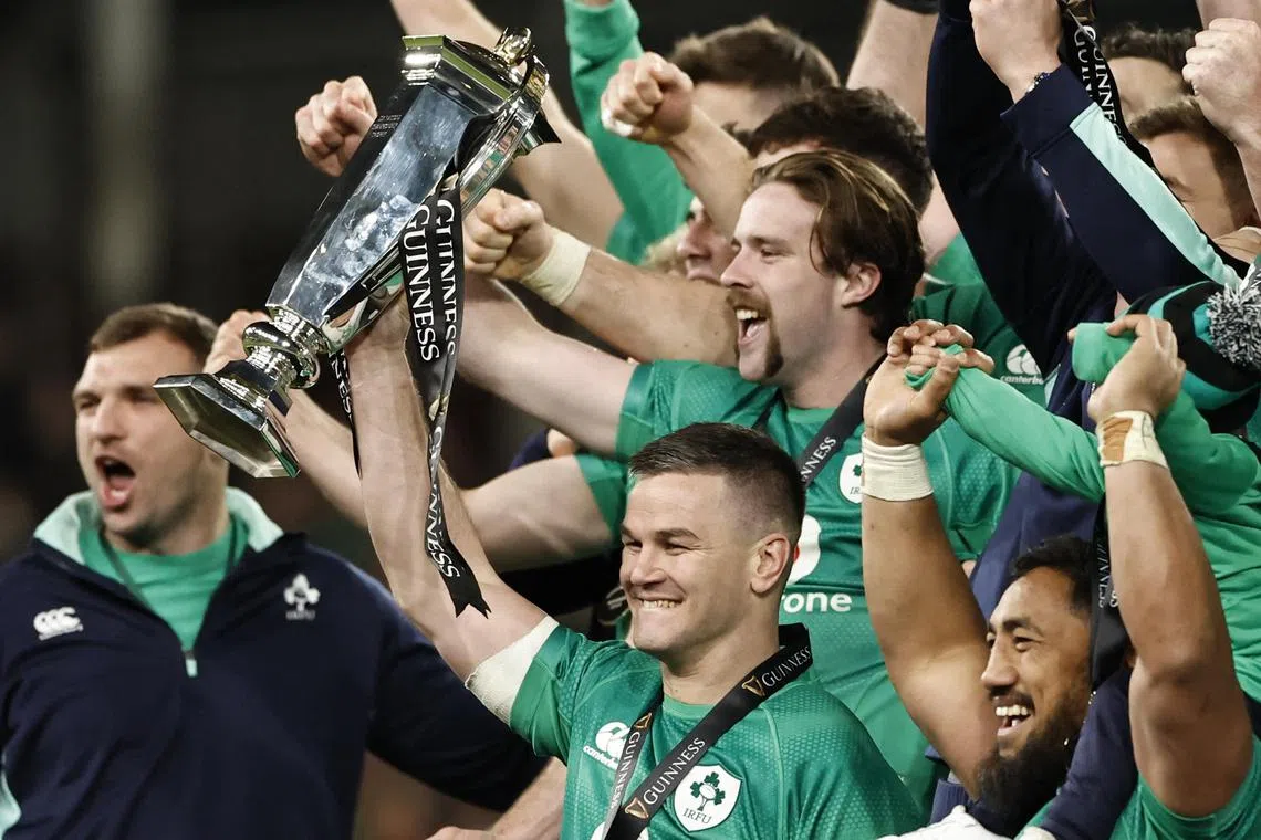Ireland captain Johnny Sexton lifting the trophy as his teammates celebrate winning the Six Nations Championship and the Grand Slam in Dublin on Saturday.