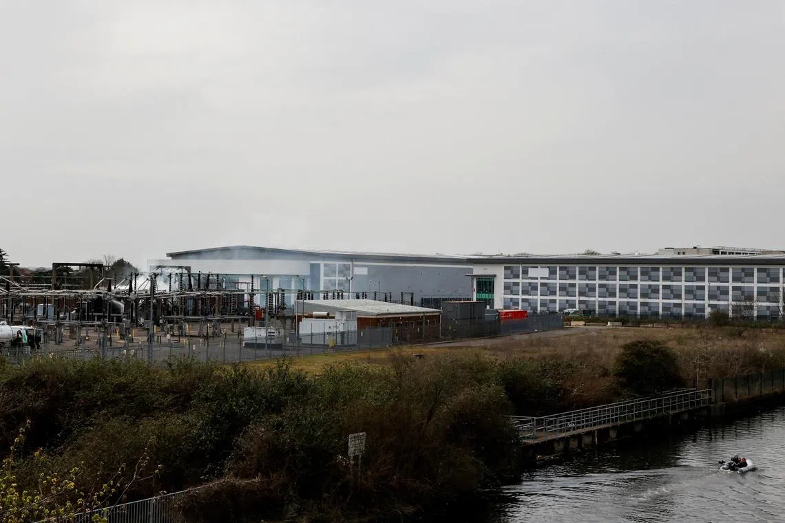 Smoke rises from the area of an electrical substation, after a fire there wiped out the power at Heathrow International Airport, in Hayes, London, Britain, March 21, 2025. REUTERS/Carlos Jasso