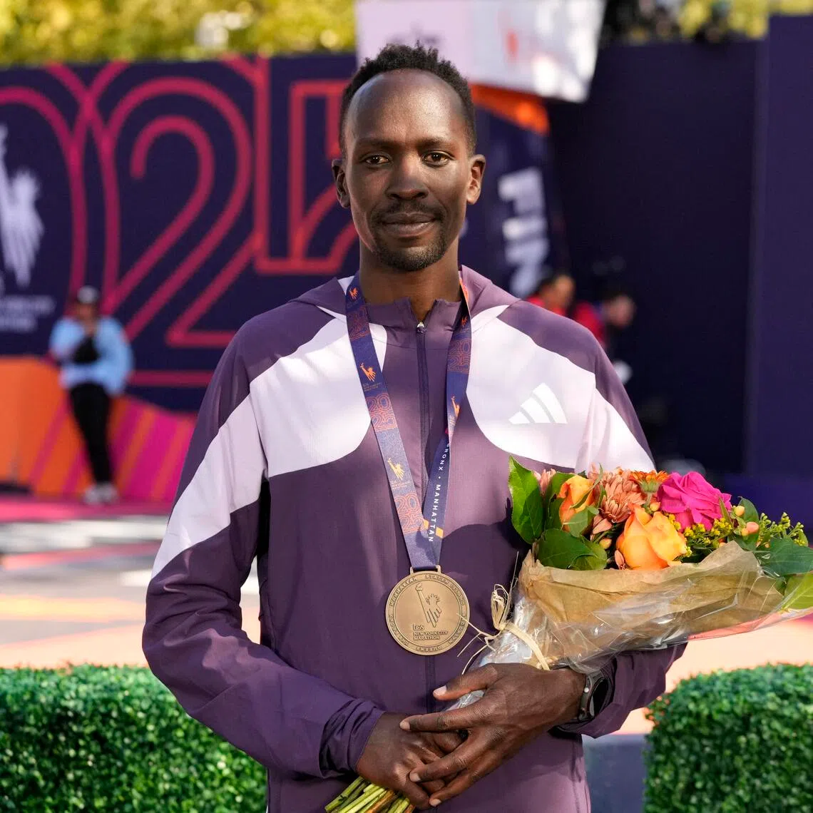 Kenya's Albert Korir celebrates on the podium after finishing third in the men's elite race at the 2025 New York marathon. 