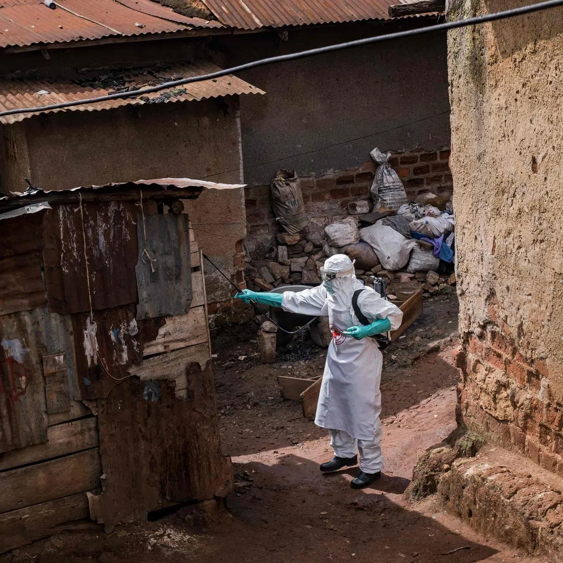 A Uganda Red Cross Society worker in protective gear disinfecting the home of a suspected Ebola victim in Kampala on May 26.
