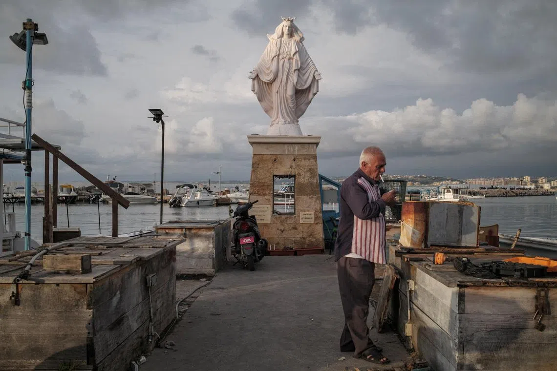 A fisherman lighting a cigarette as the sun sets, amid a temporary ceasefire between Lebanon and Israel, at the port in Tyre, southern Lebanon, on April 27, 2026. 