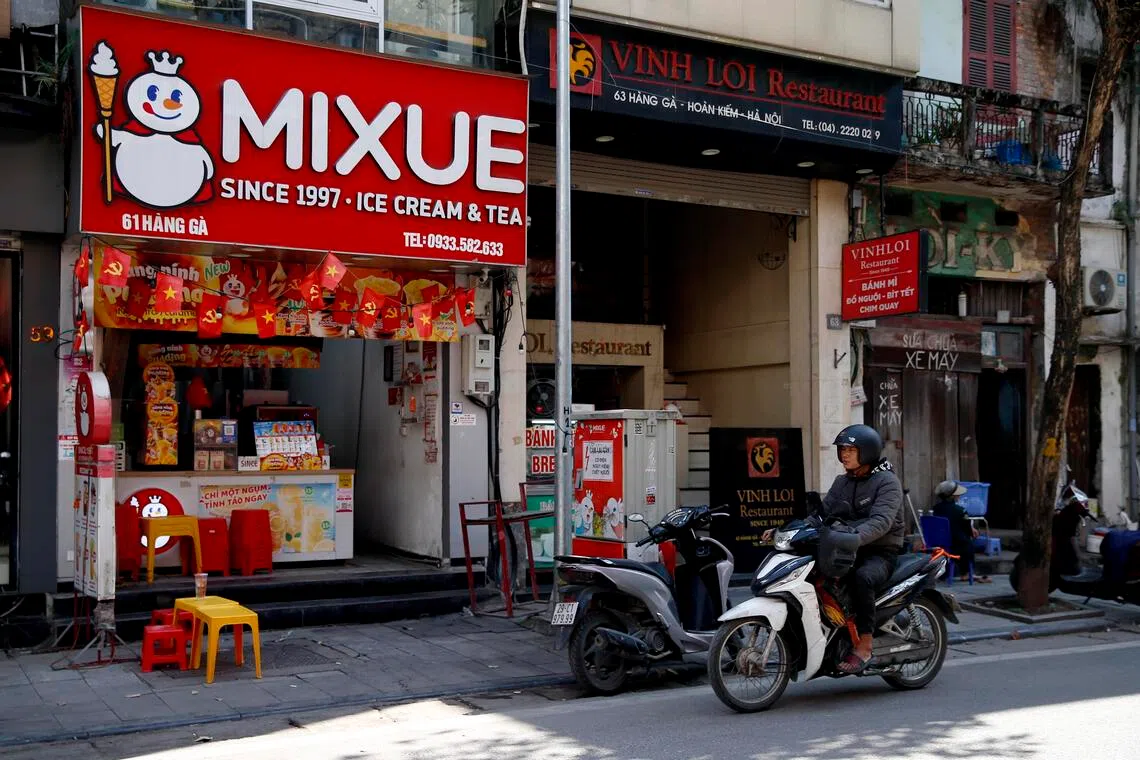 A man rides motorbike past a Mixue store in Hanoi, Vietnam, 25 November 2025.