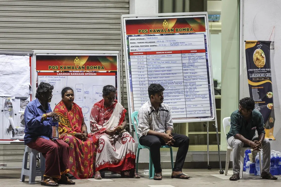 Relatives of an Indian woman who fell into an eight-meter deep sinkhole wait for news near the accident site in Kuala Lumpur, Malaysia, on Aug 23, 2024, as rescue efforts continued.. 