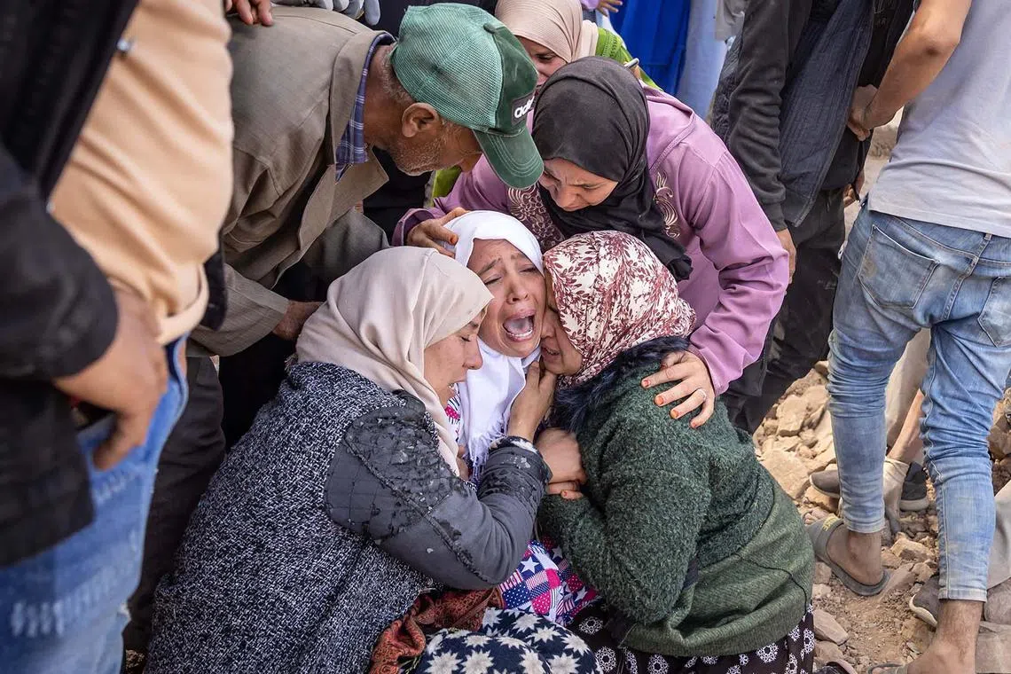 Women react as volunteers recover the body of a familly member from the rubble of collapsed houses in the village of Imi N'Tala near Amizmiz in central Morocco on Sept 10, after the deadly 6.8-magnitude earthquake.