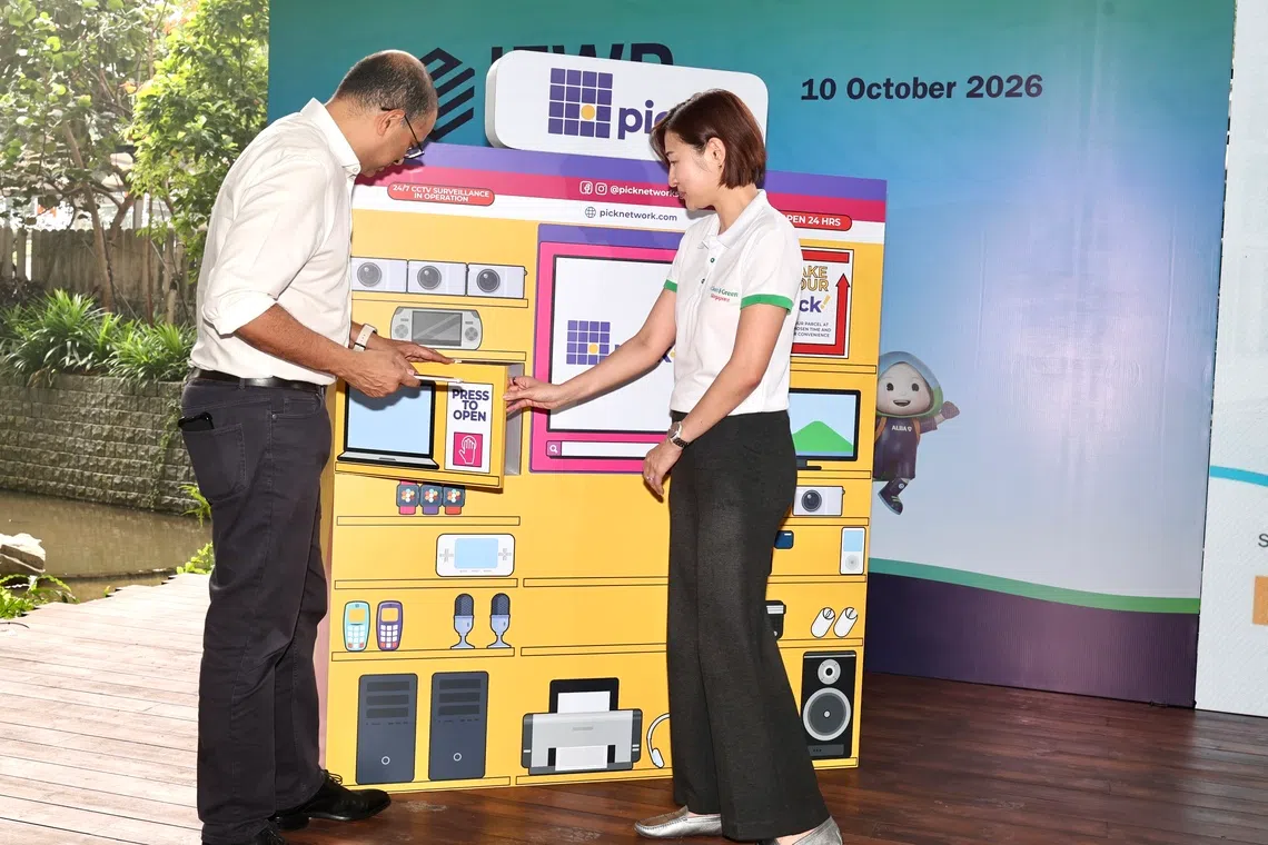 CMG20261010-ChewKW01 / 周国威 / 周岳翔 / International E-Waste Day 2026 、 GOH is Dr Janil Puthucheary, Ministry of Sustainability and the Environment and Ministry of Education ( Kampong Admiralty ). . SMS Janil together with Geraldine Low , CEO of NEA Opens a door of a recycling bin and putting in a Handphone for recycling