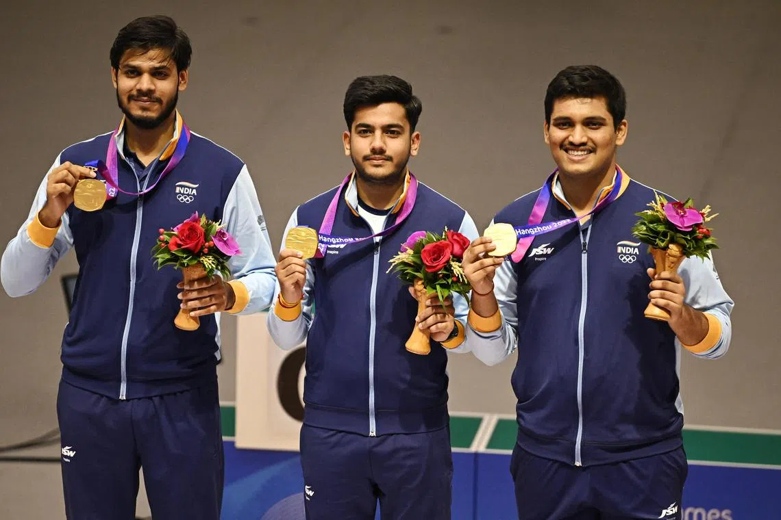 Gold medallists India's Divyansh Panwar, Aishwary Tomar and Rudrankksh Patil celebrating on the podium after winning the Asian Games men's 10m air rifle team final at the Fuyang Yinhu Sports Centre in Hangzhou.