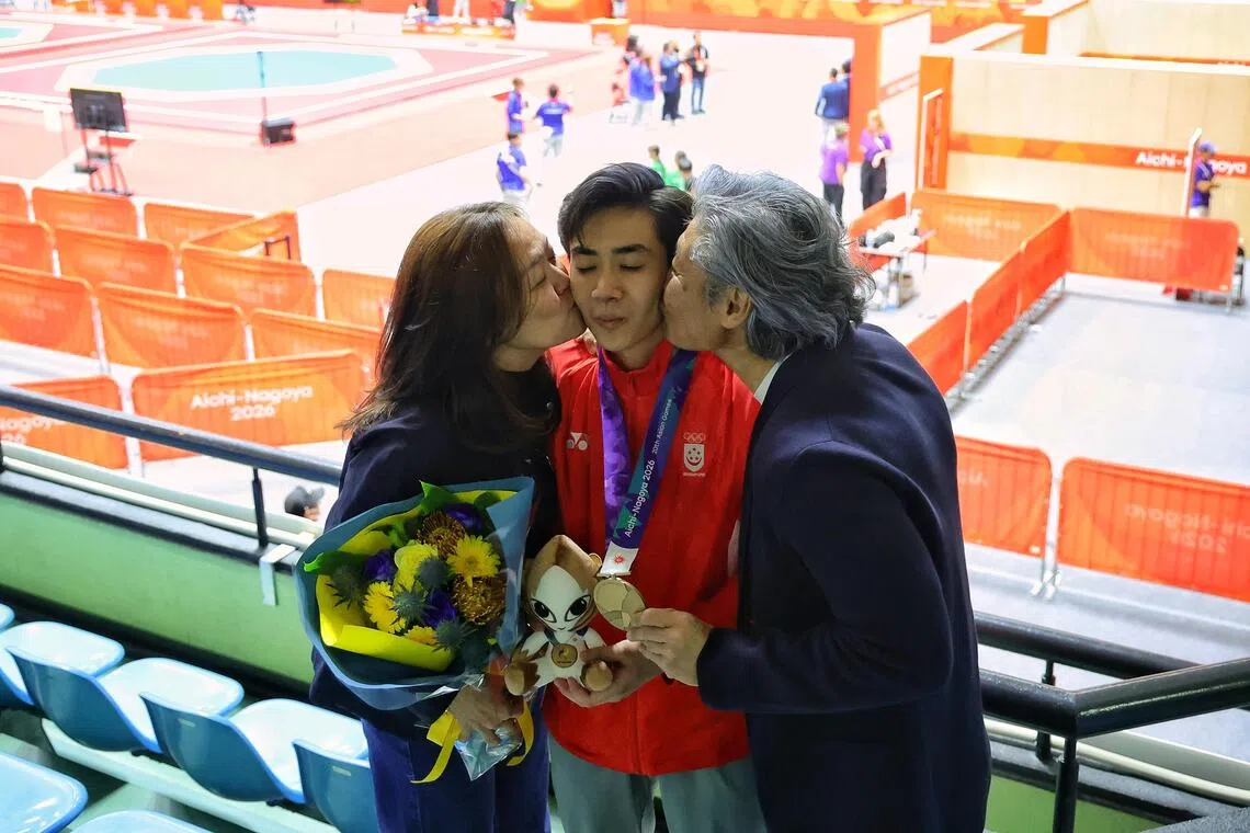 Bronze medalist Darren Yap of Singapore receiving a kiss from his parents after the Aichi-Nagoya 2026 Asian Games men individual poomsae gold medal contest at Toyohashi Gymnasium in Aichi, Japan on Oct 1, 2026. ST PHOTO: KEVIN LIM pixag01