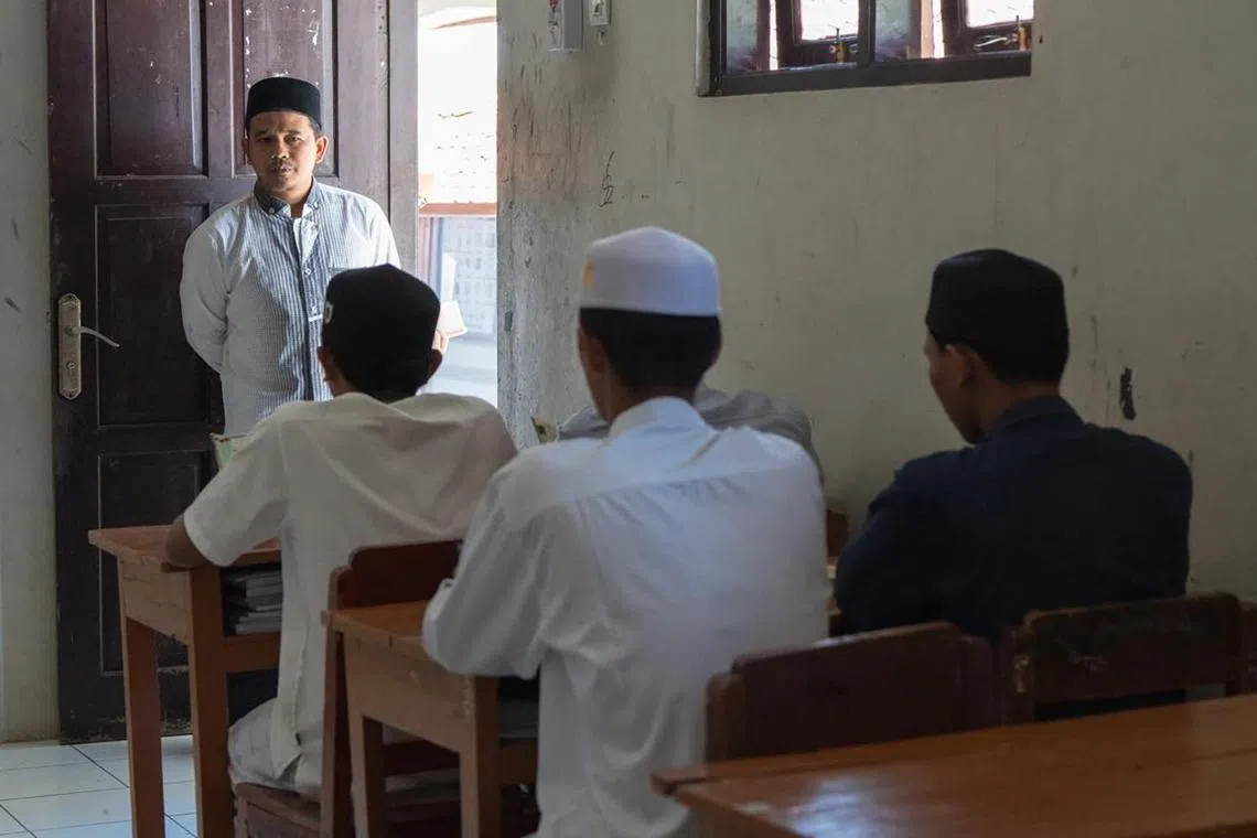 A religious teacher at Pesantren Darusy Syahadah supervises students as they recite Quranic verses on the afternoon of September 13. Besides devoting their time to the study of Islam, the students also enjoy playing sports in their free time, with mobile phones banned in the school.