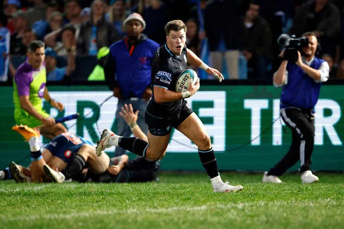 Glasgow Warriors' Scottish centre Huw Jones runs to score a try in the United Rugby Championship (URC) final against the Bulls at Loftus Versfeld stadium in Pretoria on June 22, 2024.
