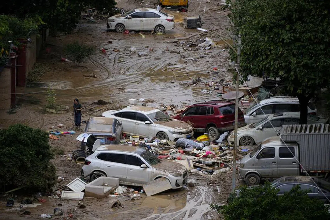 FILE PHOTO: A woman walks past mud and debris after heavy rainfall flooded Tangxia town in Dongguan, Guangdong province, China September 9, 2023. REUTERS/Aly Song/File Photo