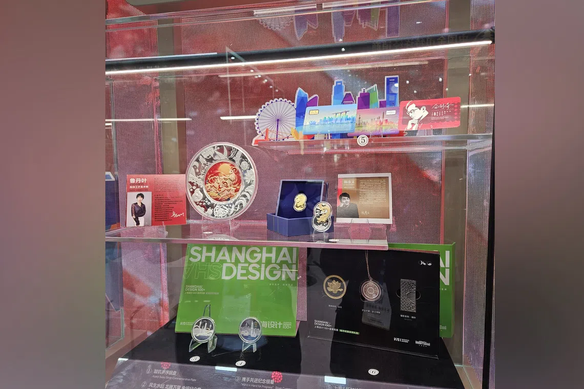 The “Rising Fortunes, Soaring Dragon and Majestic Lion” gold and silver commemorative medallions are seen on display at the Beijing International Coin Exposition on Oct 30.