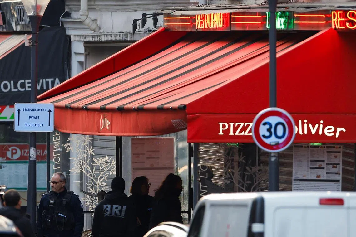 French police outside the pizza restaurant in Issy-les-Moulineaux, in Paris' suburbs, where a knife-wielding man who took four staff hostage. 