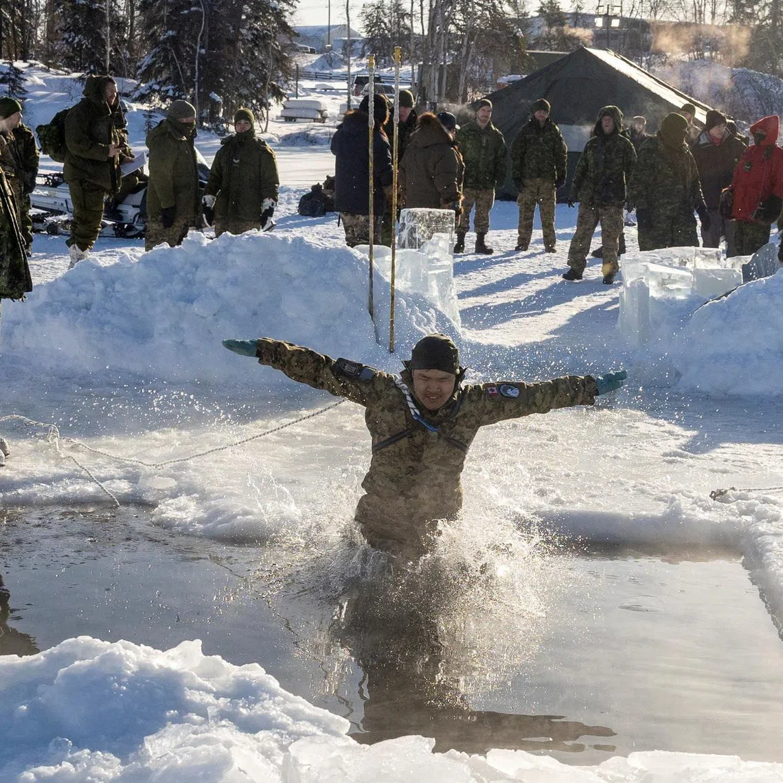 FILE PHOTO: A member of of 41 CBG pratices through the ice rescue as Canadian Armed Forces deploy to \"Operation Nanook-Nunalivut,\" a yearly series of drills designed to highlight the military's ability to defend the Canadian Arctic, in Yellowknife, Northwest Territories, Canada February 20, 2026. REUTERS/Carlos Osorio/File Photo