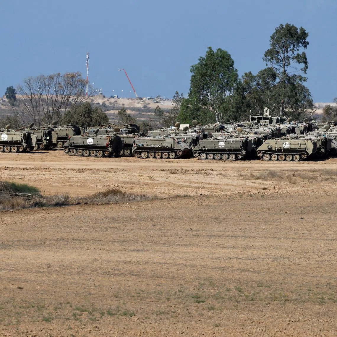 Armoured personnel carriers (APCs) stand on the Israeli side of the border with Gaza, in Israel, October 19, 2025. REUTERS/Amir Cohen/File Photo