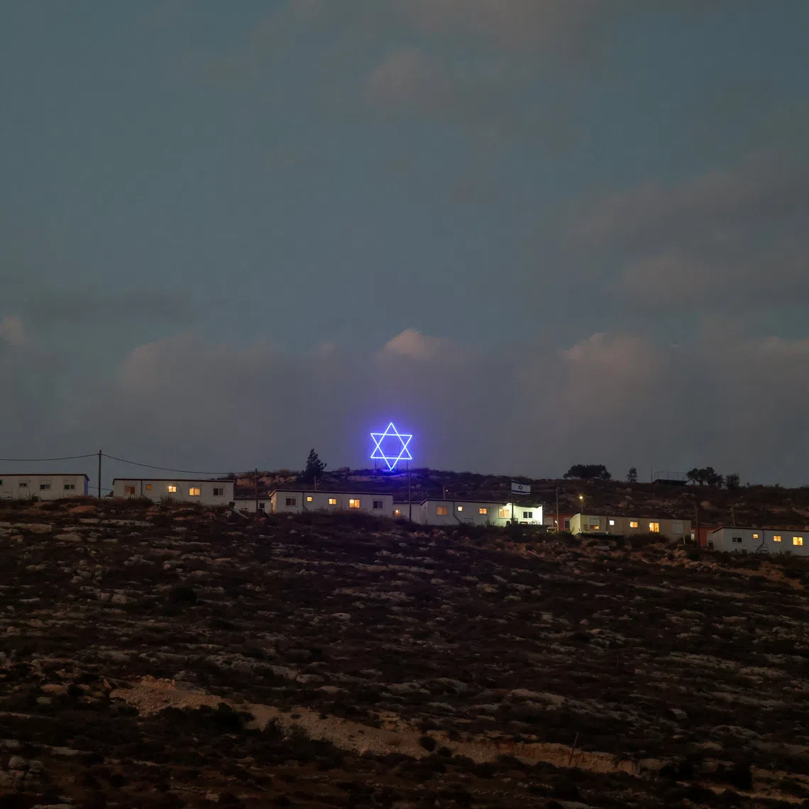An illuminated Star of David above an Israeli settlers outpost near Ramallah, in the Israeli-occupied West Bank.